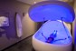Person floating in an isolation tank with blue light.